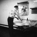 A man has a shave in a public toilets Image preview