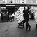 A porter in Covent Garden with a cargo of crates of fruit or vegetables Image preview