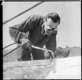 A man repairs a ship moored in a London dock Image preview