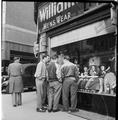 Men stand outside Williams and Co Menswear on the corner of Charing Cross Road Image preview