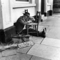 A London tradesman repairs a chair on the street Image preview